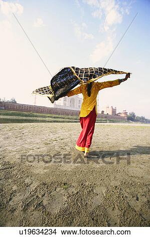 Picture - Rear view of a young woman holding her stole on the riverbank, Taj Mahal, Agra, Uttar Pradesh, India. Fotosearch