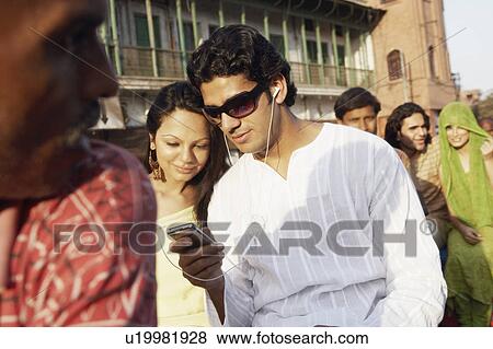 Stock Photo - Young couple listening to an MP3 player. Fotosearch