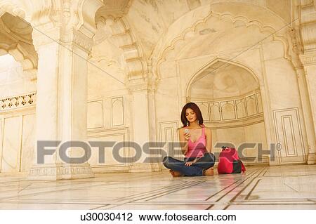 Young woman sitting on the floor in an archway View Large Photo Image Stock Image - Young woman sitting on the floor in an archway. Fotosearch