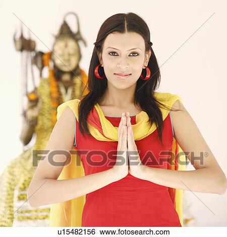 Close-up of a young woman standing in a prayer position in front of an idol of Lord Shiva View Large Photo Image Stock Photograph - Close-up of a young woman standing in a prayer position in front of an idol of Lord Shiva. Fotosearch