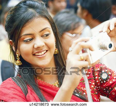 Close-up of a young woman taking a photograph View Large Photo Image Stock Image - Close-up of a young woman taking a photograph. Fotosearch