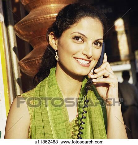 Close-up of a young woman talking on the telephone View Large Photo Image Stock Photo - Close-up of a young woman talking on the telephone. Fotosearch