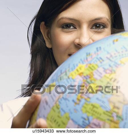 Stock Image - Portrait of a businesswoman holding a globe. Fotosearch