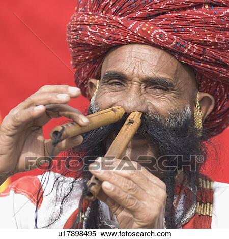 Stock Photography - Portrait of a mature man playing flutes with his nose, Jaipur, Rajasthan, India. Fotosearch