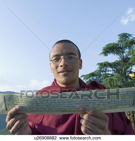 Portrait of a mid adult man smiling and holding a religious book, Namgyal Monastery, McLeod Ganj, Dharamshala, Himachal Pradesh, India View Large Photo Image Stock Image - Portrait of a mid adult man smiling and holding a religious book, Namgyal Monastery, McLeod Ganj, Dharamshala, Himachal Pradesh, India. Fotosearch