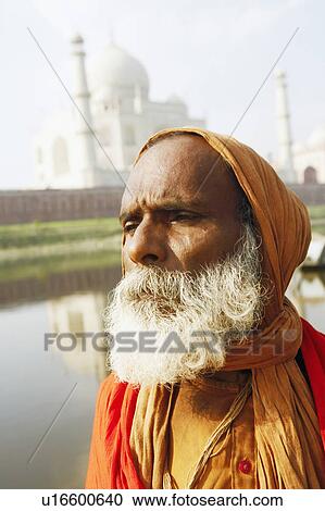 Stock Image - Close-up of a priest standing on the riverbank, Taj Mahal, Agra, Uttar Pradesh, India. Fotosearch