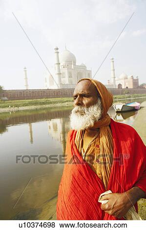 Stock Photo - Close-up of a priest standing on the riverbank, Taj Mahal, Agra, Uttar Pradesh, India. Fotosearch
