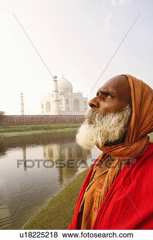 Stock Photo - Close-up of a priest standing on the riverbank and looking up, Taj Mahal, Agra, Uttar Pradesh, India. Fotosearch
