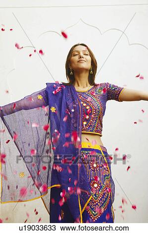 Close-up of a young woman standing with rose petals falling around her View Large Photo Image Stock Image - Close-up of a young woman standing with rose petals falling around her. Fotosearch