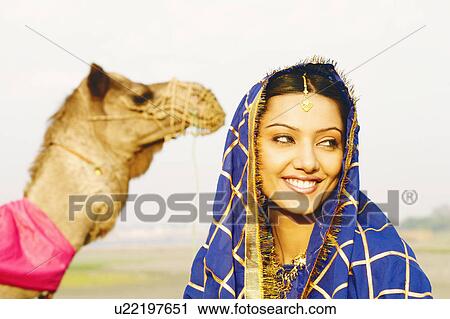 Close-up of a young woman with a camel in the background View Large Photo Image Stock Image - Close-up of a young woman with a camel in the background. Fotosearch