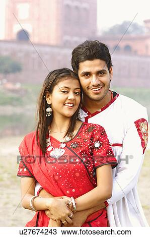 Stock Image - Portrait of a young man embracing a young woman. Fotosearch