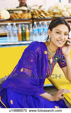 Portrait of a young woman talking on a mobile phone View Large Photo Image Stock Photography - Portrait of a young woman talking on a mobile phone. Fotosearch