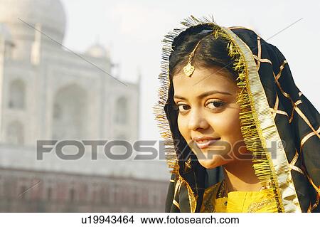 Portrait of a young woman smiling in front of a mausoleum, Taj Mahal, Agra, Uttar Pradesh, India View Large Photo Image Picture - Portrait of a young woman smiling in front of a mausoleum, Taj Mahal, Agra, Uttar Pradesh, India. Fotosearch