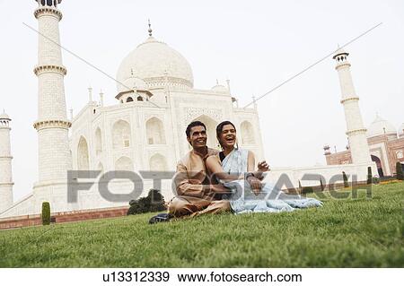 Young couple sitting in front of a mausoleum, Taj Mahal, Agra, Uttar Pradesh, India View Large Photo Image Stock Photo - Young couple sitting in front of a mausoleum, Taj Mahal, Agra, Uttar Pradesh, India. Fotosearch
