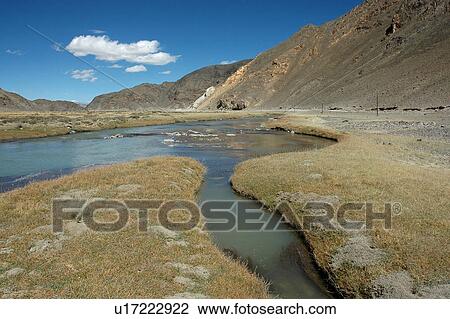 Stock Image - View of a lake amid mountains.. Fotosearch