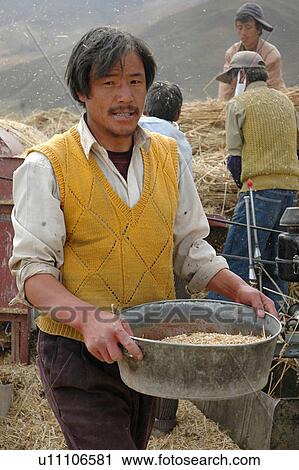 View of farmers working in a field near a hill. View Large Photo Image Stock Image - View of farmers working in a field near a hill.. Fotosearch