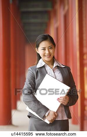 Business woman holding a laptop, smiling View Large Photo Image Stock Photography - Business woman holding a laptop, smiling. Fotosearch