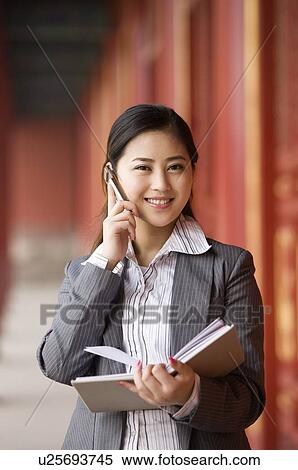 Stock Photography - Business woman on the phone in corridor. Fotosearch