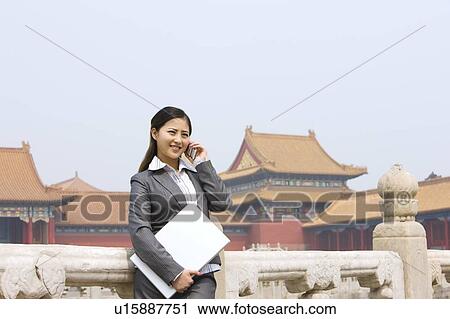 Business woman on the phone with laptop in her hand View Large Photo Image Stock Image - Business woman on the phone with laptop in her hand. Fotosearch