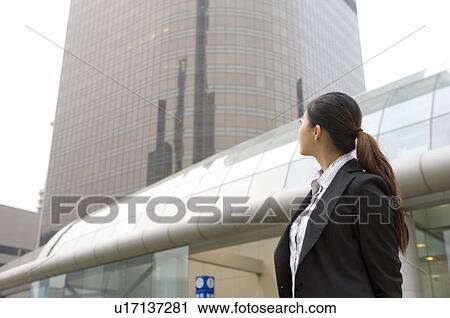 Stock Image - Business woman raising her head looking. Fotosearch