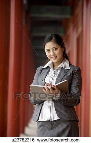 Stock Photograph - Business woman writing on her notebook. Fotosearch