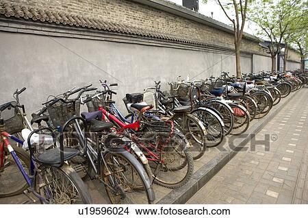 Bicycles parking in the foot of a wall View Large Photo Image Picture - Bicycles parking in the foot of a wall. Fotosearch