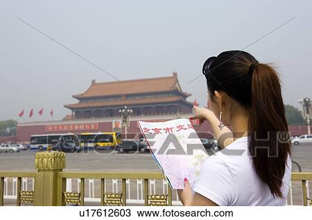Young woman pointing at Tiananmen Gate Of Heavenly Peace with a map in her hand View Large Photo Image Stock Image - Young woman pointing at Tiananmen Gate Of Heavenly Peace with a map in her hand. Fotosearch