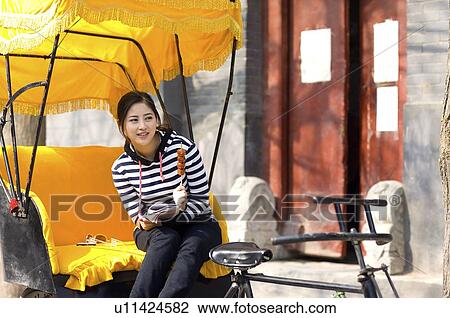 Young woman sitting on the rickshaw holding tomatoes on sticks View Large Photo Image Stock Image - Young woman sitting on the rickshaw holding tomatoes on sticks. Fotosearch