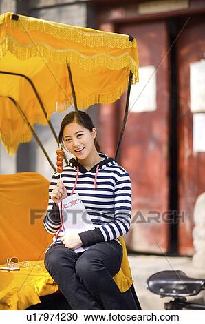 Young woman sitting on the rickshaw holding map and tomatoes on sticks View Large Photo Image Stock Image - Young woman sitting on the rickshaw holding map and tomatoes on sticks. Fotosearch