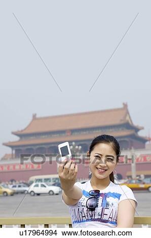 Young woman taking photograph in front of Tiananmen Square View Large Photo Image Picture - Young woman taking photograph in front of Tiananmen Square. Fotosearch