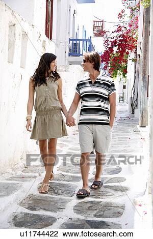 Stock Image - Couple walking in alleyway. Fotosearch