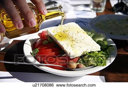 Oil being poured on Greek salad View Large Photo Image Stock Photograph - Oil being poured on Greek salad. Fotosearch