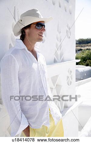 Young man in white shirt and hat View Large Photo Image Stock Photo - Young man in white shirt and hat. Fotosearch