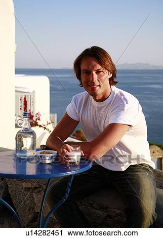 Young man sitting on balcony with a view View Large Photo Image Stock Image - Young man sitting on balcony with a view. Fotosearch