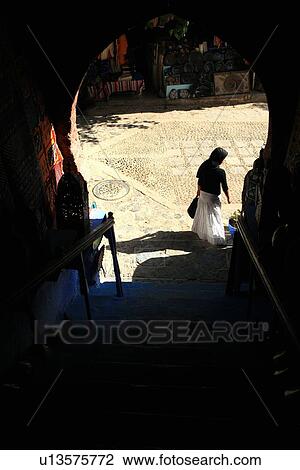 Stock Image - Woman seen through doorway on street. Fotosearch