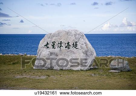 Stock Image - Rock with a sign on it in Qixingtan Scenic Area, a. k. a. Seven Star Basin in Hualien County, Taiwan. Fotosearch
