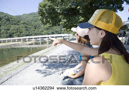 Picture - Two young women sitting in Arashiyama, Kyoto, Japan. Fotosearch