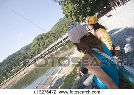 Two young women sitting in Arashiyama, Kyoto, Japan View Large Photo Image Stock Image - Two young women sitting in Arashiyama, Kyoto, Japan. Fotosearch