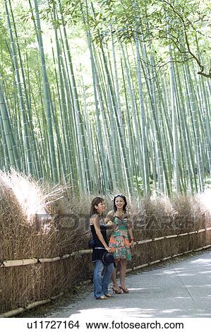 Two young women standing in bamboo forest, Sagano, Kyoto, Japan View Large Photo Image Picture - Two young women standing in bamboo forest, Sagano, Kyoto, Japan. Fotosearch
