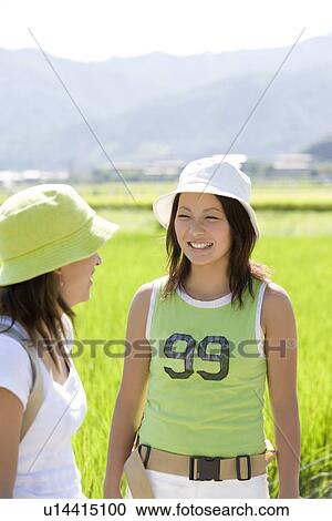 Two young women talking View Large Photo Image Stock Image - Two young women talking. Fotosearch