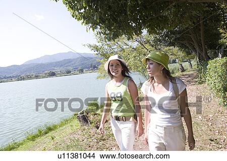 Picture - Two young women walking by Hirosawa Pond, Kyoto, Japan. Fotosearch