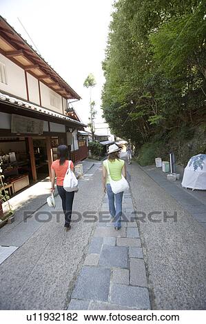 Stock Image - Two young women walking in old town. Fotosearch