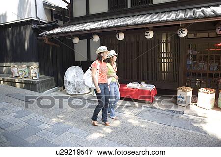 Stock Photo - Two young women walking in old town. Fotosearch