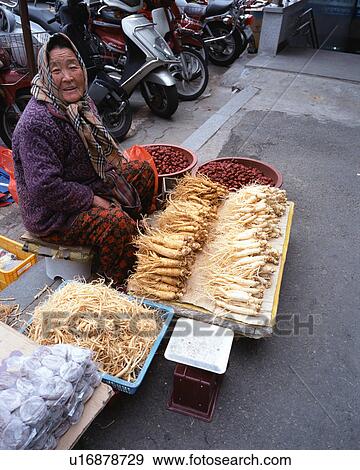 Stock Photo - Senior woman selling herbal medicine at street. Fotosearch
