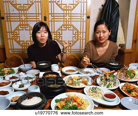 Two women eating Korean food View Large Photo Image Stock Photograph - Two women eating Korean food. Fotosearch