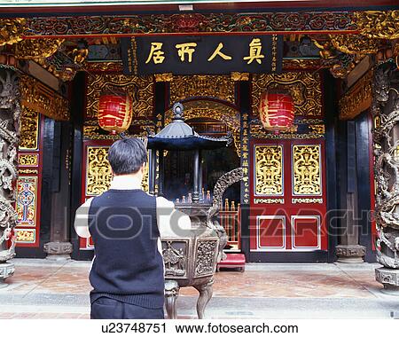 Stock Image - A man praying at Baoan Temple, Taipei, Taiwan. Fotosearch