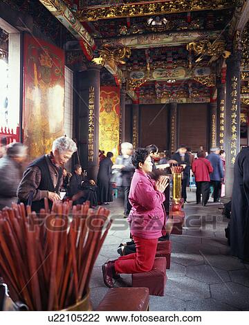 Stock Image - People praying at temple. Fotosearch