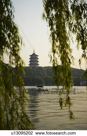 Stock Image - The Six Harmonies Pagoda and a small boat, West Lake in Hangzhou, Zhejiang Province, People Republic of China. Fotosearch