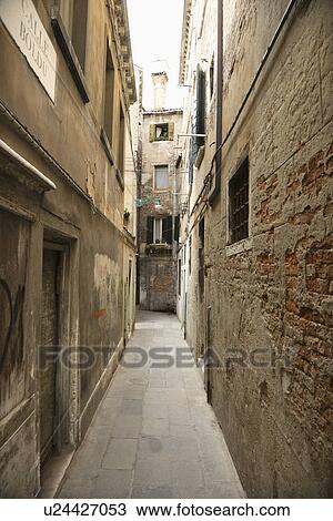 Stock Image - Alleyway between buildings in Venice, Italy.. Fotosearch