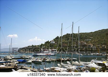 Stock Image - Boats in marina next to coastal villa.. Fotosearch